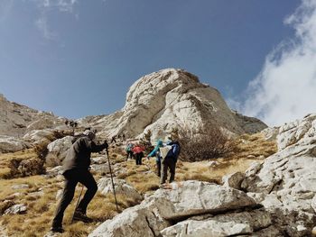 Low angle view of hikers climbing zavizan against sky