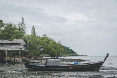 Boats moored at harbor against sky