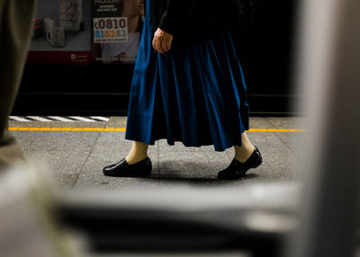 Low section of woman walking on footpath