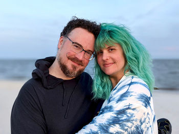 Portrait of couple kissing against water