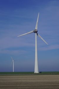 Low angle view of wind turbines against clear sky