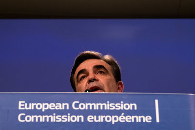 Low angle portrait of man with text against blue sky