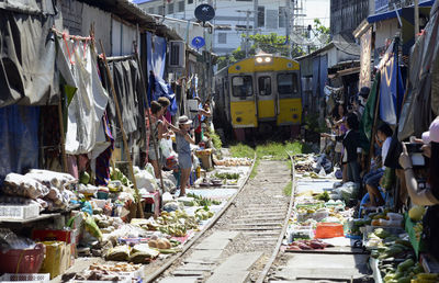 Train passing through vegetable market during sunny day