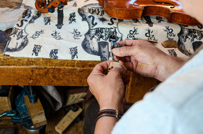 Violin maker luthier changing bridge of a handmade baroque violin