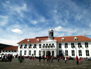 People in front of building against sky