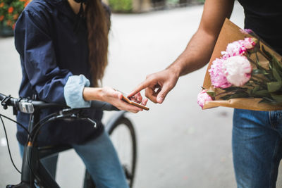 Midsection of couple holding bicycle in city