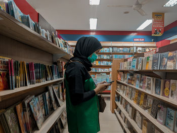 Side view of man reading book