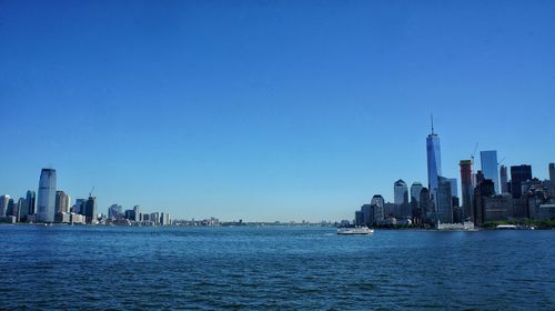 Cityscape by water bay against sky