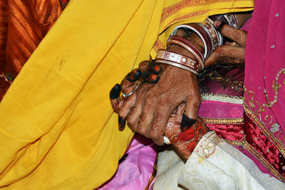 Bride and groom henna painted hand completes hand matching ceremony in indian wedding traditions