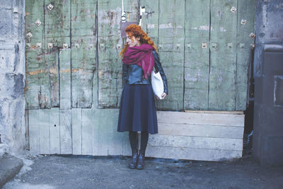Full length of young woman standing by railing