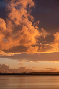 Scenic view of sea against dramatic sky during sunset