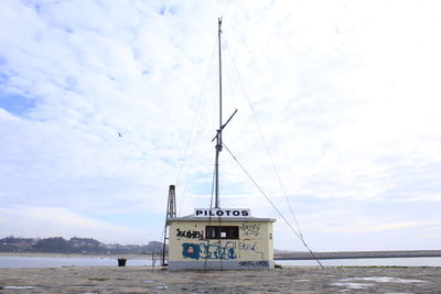 Information sign on beach against sky