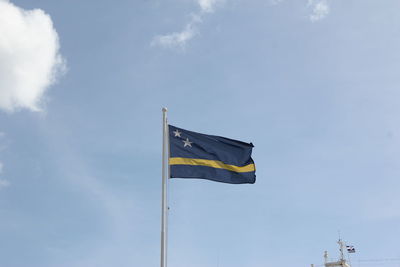 Low angle view of flag against blue sky