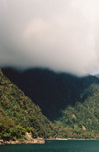 Scenic view of sea and mountains against sky