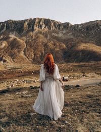 Rear view of woman standing on field