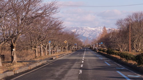 Road amidst trees against sky