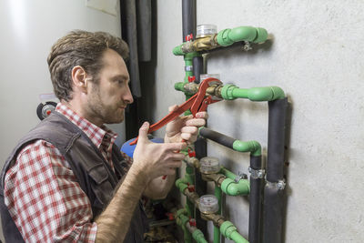 Side view of man working against wall