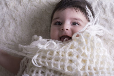 Portrait of cute baby lying on bed