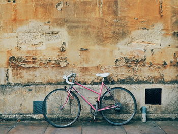 Bicycle parked against old wall