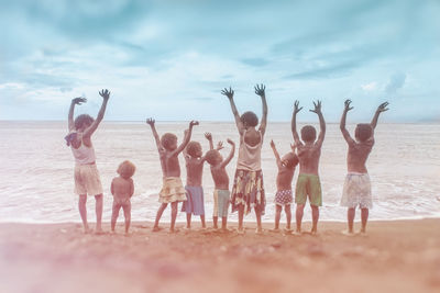 Group of people at beach against sky