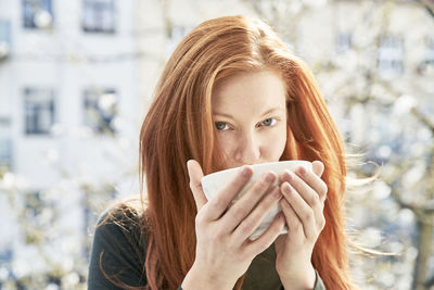 Portrait of young woman drinking coffee