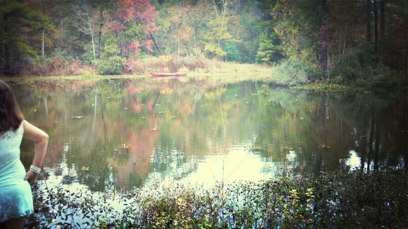 water, lake, reflection, tree, lifestyles, leisure activity, tranquility, men, nature, standing, beauty in nature, tranquil scene, river, forest, person, outdoors, unrecognizable person, rear view