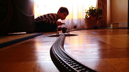 Boy playing with toy train at home