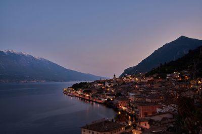 Scenic view of sea and buildings against sky at sunset