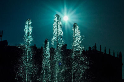 Low angle view of illuminated buildings against sky at night