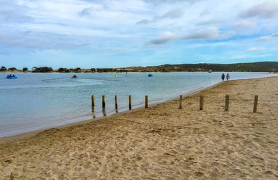 Scenic view of beach against cloudy sky