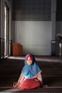 Portrait of girl in hijab sitting at mosque