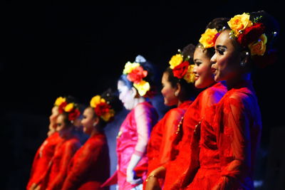 Group of people standing on flowering plant at night