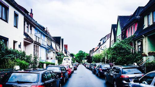 Cars on city street against sky