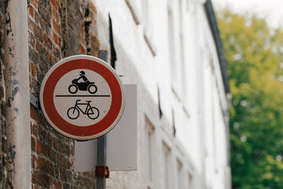 Old street sign on brick wall bicycle and motorbike forbidden