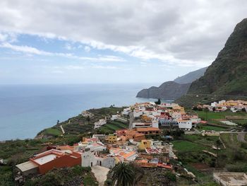 Town by sea against sky