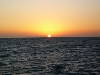 Scenic view of sea against orange sky