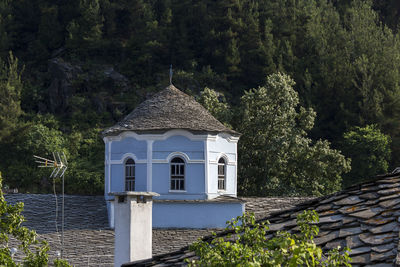 Traditional building by trees against sky