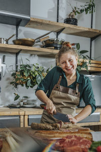 Smiling young woman eating food in store