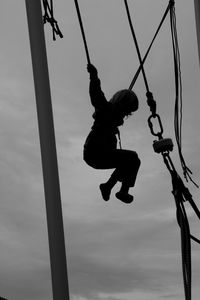 Low angle view of swing hanging on rope