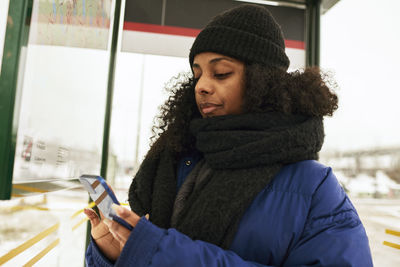 Woman using phone at bus stop