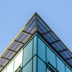 Low angle view of modern building against clear blue sky