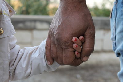 Midsection of couple holding hands