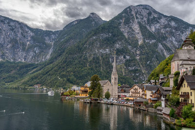 Panoramic view of lake and buildings against cloudy sky