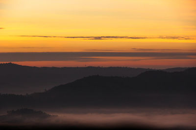 Scenic view of silhouette mountains against romantic sky at sunset