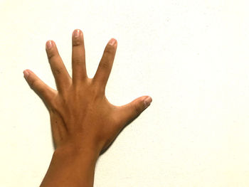 Close-up of hand against wall