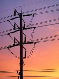 Low angle view of silhouette electricity pylon against romantic sky