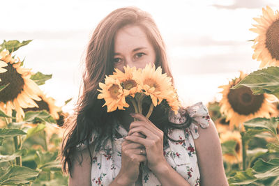 Close-up portrait of smiling woman holding flower