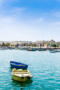 Boats moored in sea against sky