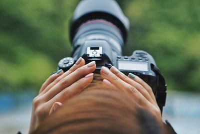 High angle view of woman photographing through camera against trees