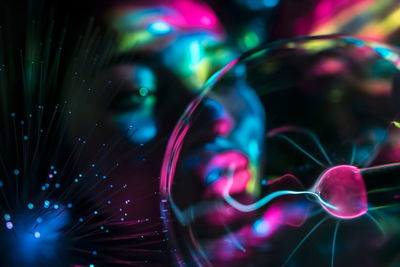 Digital composite image of woman and plasma ball with fiber optics